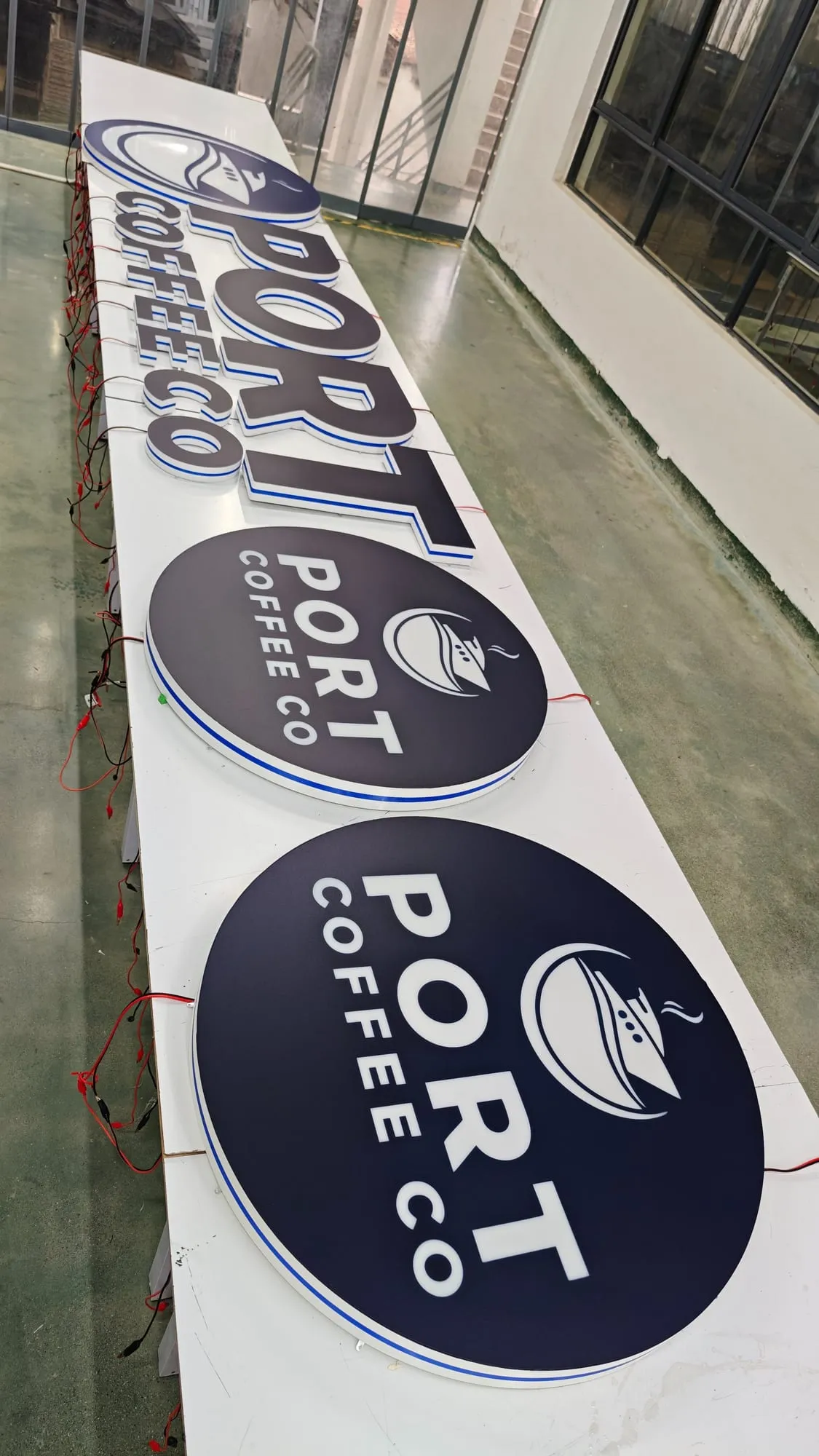 The same round signs and letters switched off, with dark navy faces, white lettering and a thin blue edge line.